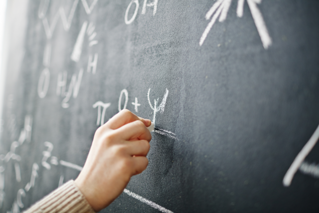 Hand-writing-formula-on-blackboard-397761